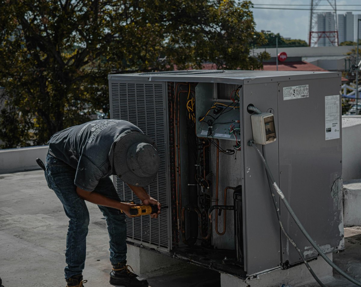Certified HVAC technician servicing commercial air conditioning unit